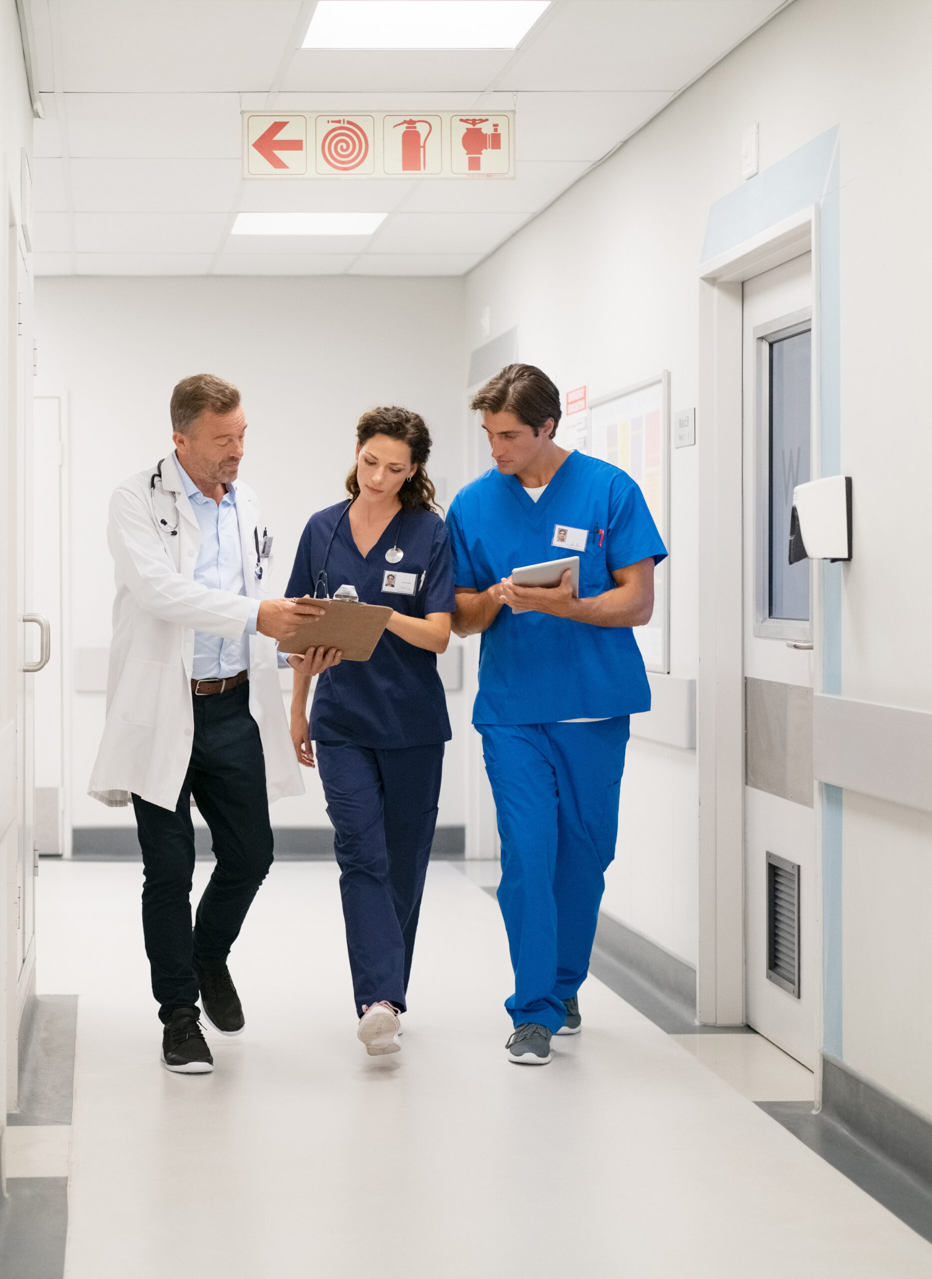 Medical,Team,Walking,In,Hurry,And,Interacting,At,Clinic.,Mature